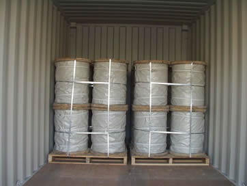 Several spools of PC strand wrapped with white PP woven bag, then on wooden pallet and tied up by baling strips.